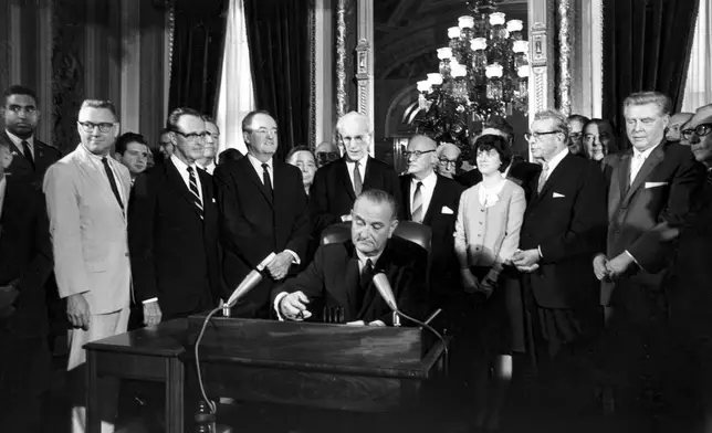 FILE - President Lyndon B. Johnson signs the Voting Rights Act of 1965 in a ceremony in the President's Room near the Senate chambers in Washington, Aug. 6, 1965. Surrounding the president from left directly above his right hand, Vice President Hubert Humphrey; Speaker John McCormack; Rep. Emanuel Celler, D-N.Y.; Luci Johnson; and Sen. Everett Dirksen, R-Ill. Behind Humphrey is House Majority Leader Carl Albert of Oklahoma; and behind Celler is Sen. Carl Hayden, D-Ariz. (AP Photo, File)