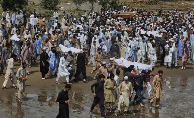 People carry bodies of victims of Friday's flash flooding, after funeral prayers at a village near Pir Baba, Buner district, in Pakistan's northwest, Saturday, Aug.16, 2025. (AP Photo/Muhammad Sajjad)