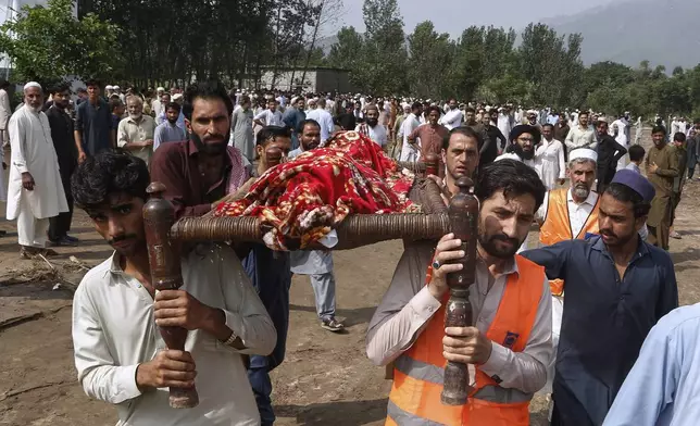 People carry the body of a victim of Friday's flash flooding, after funeral prayers at a village near Pir Baba, Buner district, in Pakistan's northwest, Saturday, Aug.16, 2025. (AP Photo/Muhammad Sajjad)