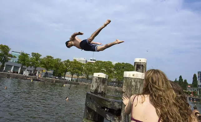People swim to cool down during hot weather in Amsterdam, Netherlands, Wednesday, Aug. 13, 2025. (AP Photo/Peter Dejong)
