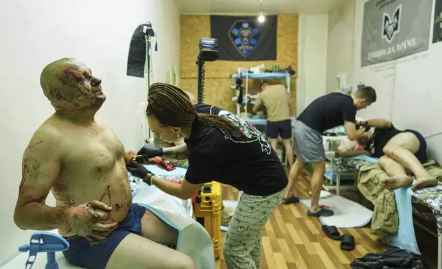 Medics of Da Vinci Wolves Battalion treat Ukrainian soldiers injured during fighting with Russian forces on the front line at stabilization point on Pokrovsk direction, Ukraine, on Monday, Aug. 11, 2025. (AP Photo/Evgeniy Maloletka)