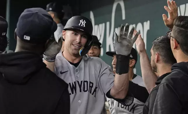 New York Yankees' Paul Goldschmidt, center, celebrates with the team after hitting a solo home run in the seventh inning of a baseball game against the Texas Rangers Wednesday, Aug. 6, 2025, in Arlington, Texas. (AP Photo/Tony Gutierrez)