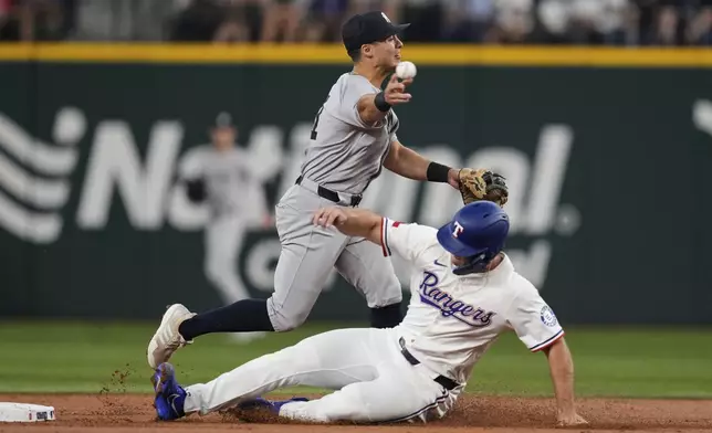 New York Yankees shortstop Anthony Volpe throws to first to complete the double play after forcing Texas Rangers' Wyatt Langford at second in the second inning of a baseball game Wednesday, Aug. 6, 2025, in Arlington, Texas. (AP Photo/Tony Gutierrez)
