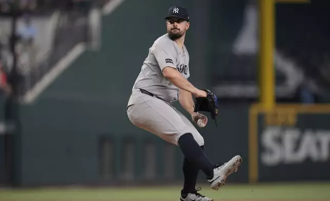 New York Yankees starting pitcher Carlos Rodon winds up to throw to the Texas Rangers in the first inning of a baseball game Wednesday, Aug. 6, 2025, in Arlington, Texas. (AP Photo/Tony Gutierrez)