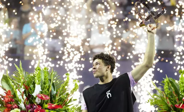 Ben Shelton, of the United States, lifts the trophy as he celebrates after his win over Karen Khachanov, of Russia, in the final match at the National Bank Open men's tennis tournament in Toronto, Thursday, Aug. 7, 2025. (Frank Gunn/The Canadian Press via AP)