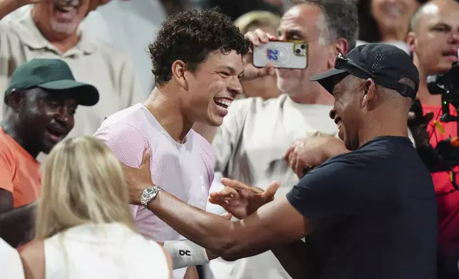 Ben Shelton, center, of the United States, celebrates after his win over Karen Khachanov, of Russia, with his father Bryan Shelton, right, after the final match at the National Bank Open men's tennis tournament in Toronto, Thursday, Aug. 7, 2025. (Frank Gunn/The Canadian Press via AP)
