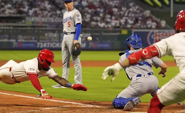 Los Angeles Angels' Luis Rengifo, left, scores on a double by Bryce Teodosio as Los Angeles Dodgers catcher Dalton Rushing, second from right, waits for the ball and first baseman Freddie Freeman, second from left, watches along with Zach Neto, right, during the fourth inning of a baseball game Tuesday, Aug. 12, 2025, in Anaheim, Calif. (AP Photo/Mark J. Terrill)