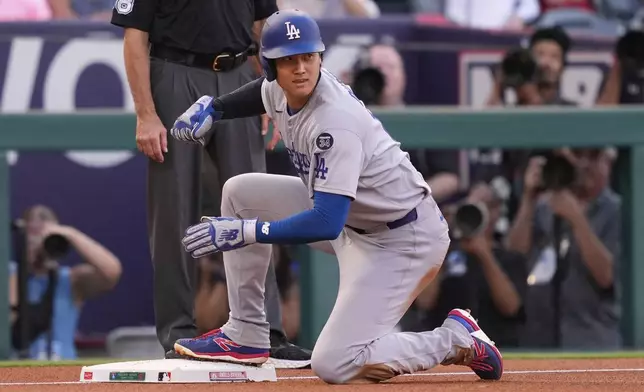 Los Angeles Dodgers' Shohei Ohtani looks up after sliding into third while advancing on a sacrifice fly hit by Freddie Freeman during the first inning of a baseball game against the Los Angeles Angels, Tuesday, Aug. 12, 2025, in Anaheim, Calif. (AP Photo/Mark J. Terrill)