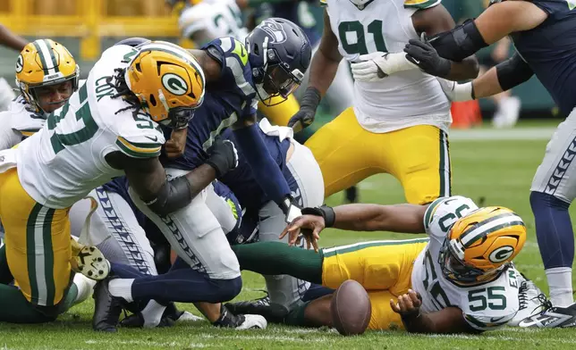 Green Bay Packers' Kingsley Enagbare recovers a fumble by Seattle Seahawks' Jalen Milroe during the first half of a preseason NFL football game Saturday, Aug. 23, 2025, in Green Bay, Wis. (AP Photo/Mike Roemer)