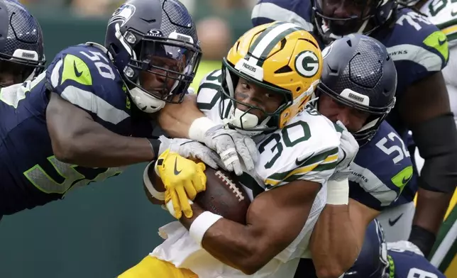 Seattle Seahawks' Jamie Sheriff and Patrick O'Connell stop Green Bay Packers' Chris Brooks during the first half of a preseason NFL football game Saturday, Aug. 23, 2025, in Green Bay, Wis. (AP Photo/Matt Ludtke)