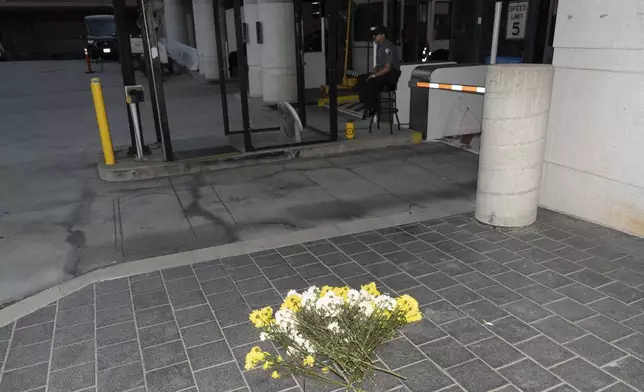 Flowers are placed outside the Metropolitan Detention Center in Los Angeles, Tuesday, Aug. 5, 2025. (AP Photo/Jae C. Hong)