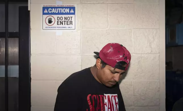 Day laborer Antonio, an immigrant from Guatemala, stands outside a day labor center in the parking lot of a Home Depot where a sign warns that law enforcement needs a warrant to enter, in Los Angeles, Friday, July 25, 2025. (AP Photo/Jae C. Hong)