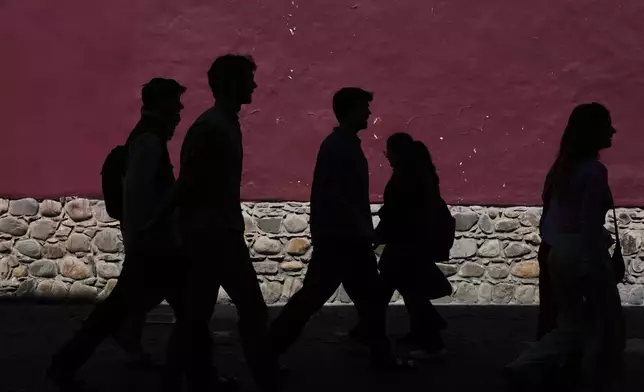 Pedestrians walk in La Paz, Bolivia, Monday, Aug. 18, 2025. (AP Photo/Juan Karita)