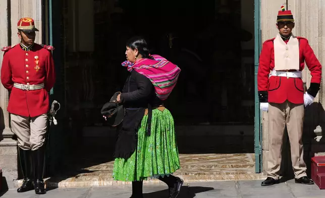 A woman walks past the government palace in La Paz, Bolivia, Monday, Aug. 18, 2025, the day after the presidential election which is headed to a runoff. (AP Photo/Juan Karita)