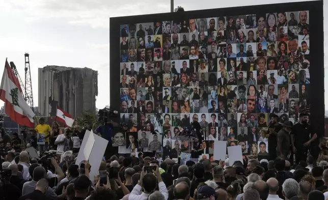 Relatives of victims of the deadly 2020 Beirut port explosion hold portraits of their loved ones during a gathering marking the fifth anniversary of the massive blast, outside the port of Beirut, Lebanon, Monday, Aug. 4, 2025. (AP Photo/Hassan Ammar)