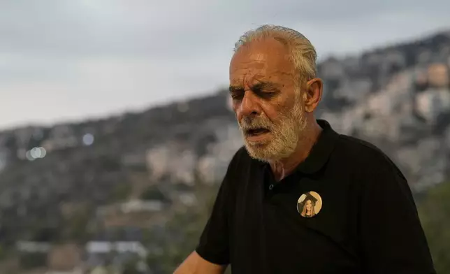 George Bezdjian, father of Jessica Bezdjian who was killed in the massive 2020 blast at Beirut's seaport, wears a pin bearing her photo as he speaks during an interview at his home in Bsalim, Lebanon, Saturday, Aug. 2, 2025. (AP Photo/Hassan Ammar)