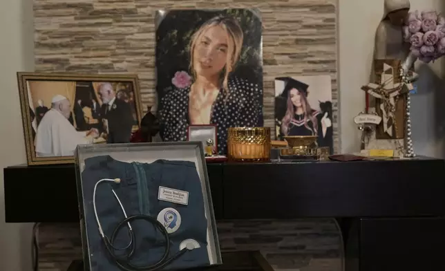 A display honoring Jessica Bezdjian, a nursing student who was killed in the massive 2020 blast at Beirut's seaport, shows her nursing uniform and personal items at her family's home in Bsalim, Lebanon, Saturday, Aug. 2, 2025. (AP Photo/Hassan Ammar)