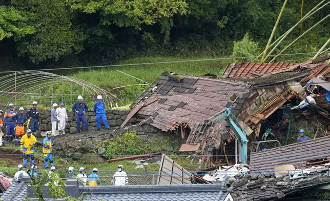 Rescuers conduct a search operation around a house damaged by a landslide following a heavy rain in Aira, Kagoshima prefecture, southern Japan Saturday, Aug. 9, 2025. (Naoki Hiraoka/Kyodo News via AP)