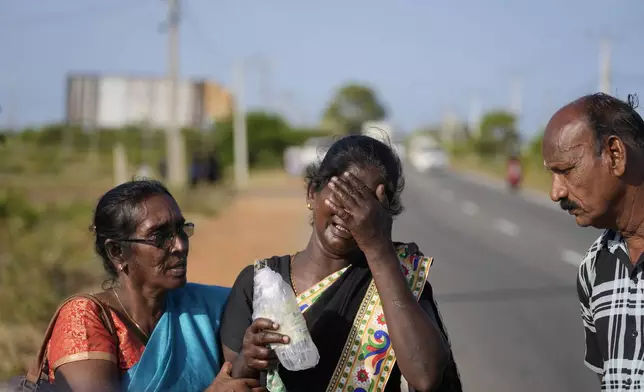Senthilvel Sothiladchumi, an ethnic Sri Lankan Tamil, center, whose son went missing during the Sri Lankan civil war, cries as she leaves the site of a mass grave where authorities exhibited unearthed belongings in an effort to secure the identities of the victims, in Chemmani, Sri Lanka, Aug. 5, 2025. (AP Photo/Eranga Jayawardena)