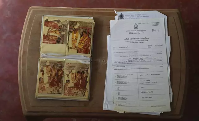 Wedding photos of Sri Lankan ethnic Tamils Sanmugam Satkunarasa and Ranjanidevi are placed next to a certificate issued by the government declaring the husband missing, at their home in Manippai, Sri Lanka, Aug. 6, 2025. (AP Photo/Eranga Jayawardena)