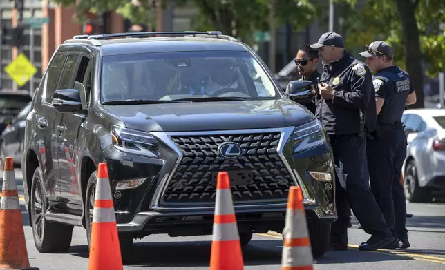 Metropolitan Police Department officers talk to a driver at a checkpoint operated by the Metropolitan Police Department and federal agencies, including officers from Immigration and Customs Enforcement (ICE) and Homeland Security Investigations (HSI), on Georgia Avenue in the northern part of Washington, Saturday, Aug. 30, 2025. (AP Photo/Mark Schiefelbein)