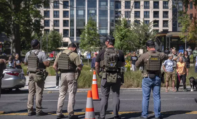 Federal agents stand at a checkpoint operated by the Metropolitan Police Department and federal agencies, including officers from Immigration and Customs Enforcement (ICE) and Homeland Security Investigations (HSI), on Georgia Avenue in the northern part of Washington, Saturday, Aug. 30, 2025. (AP Photo/Mark Schiefelbein)