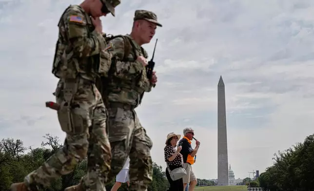 Visitors and members of the U.S. National Guard walk near the Lincoln Memorial, Thursday, Aug. 28, 2025, in Washington. (AP Photo/Jon Cherry)