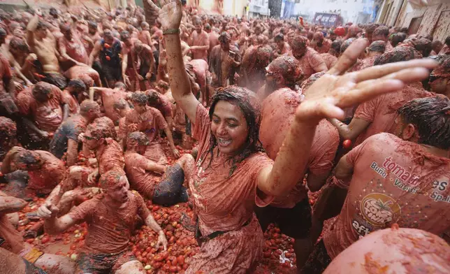 Revelers throw tomatoes at each other during the annual "Tomatina" tomato fight fiesta, in the village of Bunol near Valencia, Spain, Wednesday, Aug. 27, 2025. (AP Photo/Alberto Saiz)