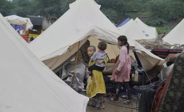 Families shelter at a relief camp set up for people who fled their homes following torrential rains and rising water level in the Ravi river, on the outskirts of in Lahore, Pakistan, Sunday, Aug. 31, 2025. (AP Photo/K.M. Chaudary)