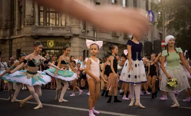 Children of the Romanian National Opera's Ballet Studio outside the National History Museum of Romania during Dance Night, an event featuring a wide variety of dance styles performed on the Calea Victoriei avenue in Bucharest, Romania, Saturday, Aug. 23, 2025. (AP Photo/Andreea Alexandru)