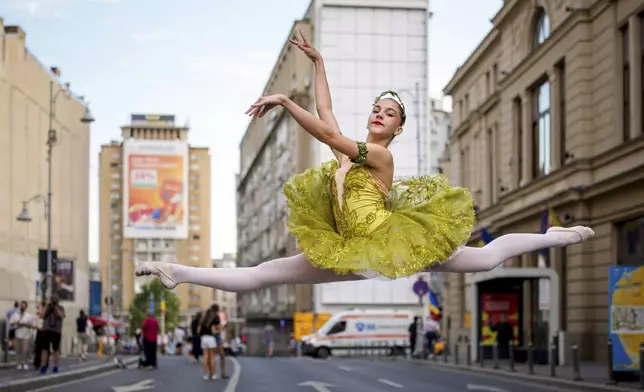 Daria Toma, 15, of the Romanian National Opera's Ballet Studio, dances outside the National History Museum of Romania during Dance Night, an event featuring a wide variety of dance styles performed on the Calea Victoriei avenue in Bucharest, Romania, Saturday, Aug. 23, 2025. (AP Photo/Andreea Alexandru)