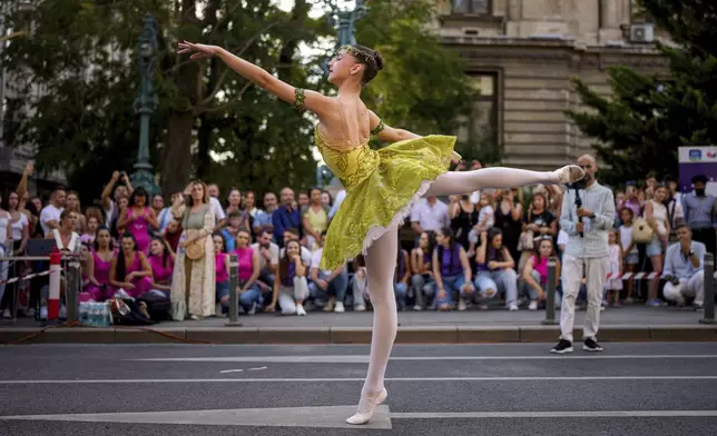 Daria Toma, 15, of the Romanian National Opera's Ballet Studio dances outside the National History Museum of Romania during Dance Night, an event featuring a wide variety of dance styles performed on the Calea Victoriei avenue in Bucharest, Romania, Saturday, Aug. 23, 2025. (AP Photo/Andreea Alexandru)
