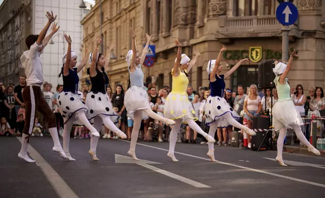 Children of the Romanian National Opera's Ballet Studio dance outside the National History Museum of Romania during Dance Night, an event featuring a wide variety of dance styles performed on the Calea Victoriei avenue in Bucharest, Romania, Saturday, Aug. 23, 2025. (AP Photo/Andreea Alexandru)