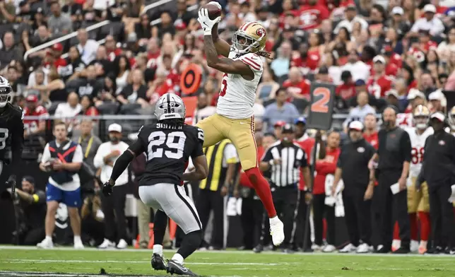 San Francisco 49ers wide receiver Demarcus Robinson (5) makes a catch over Las Vegas Raiders safety Chris Smith II (29) during the first half of a preseason NFL football game Saturday, Aug. 16, 2025, in Las Vegas. (AP Photo/David Becker)