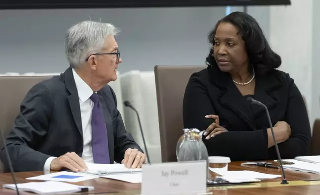 FILE - Federal Reserve Chairman Jerome Powell, left, talks with Board of Governors member Lisa Cook, right, during an open meeting of the Board of Governors at the Federal Reserve, June 25, 2025, in Washington. (AP Photo/Mark Schiefelbein, File)