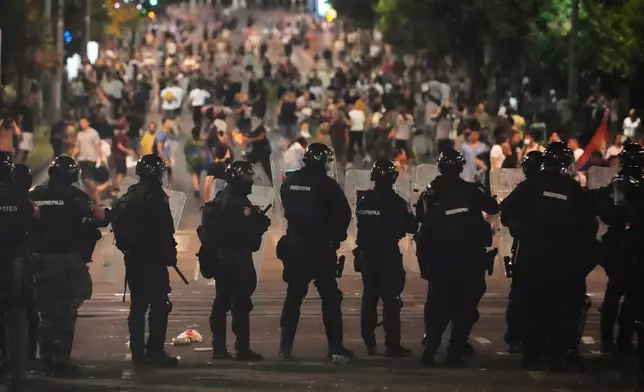 Serbian gendarmerie officers guard the street during an anti-government protest near Serbian Progressive Party office in Belgrade, Serbia, Thursday, Aug. 14, 2025. (AP Photo/Darko Vojinovic)