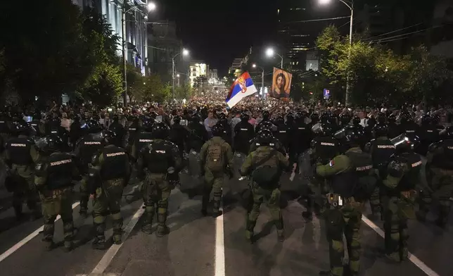 Serbian gendarmerie officers guard a street during an anti-government protest near the Serbian Progressive Party office in Belgrade, Serbia, Friday, Aug. 15, 2025. (AP Photo/Darko Vojinovic)