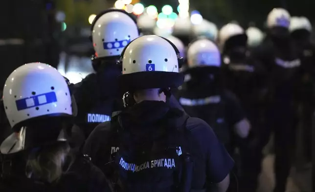 Serbian police officers guard the street during an anti-government protest near Serbian Progressive Party office in Belgrade, Serbia, Friday, Aug. 15, 2025. (AP Photo/Darko Vojinovic)