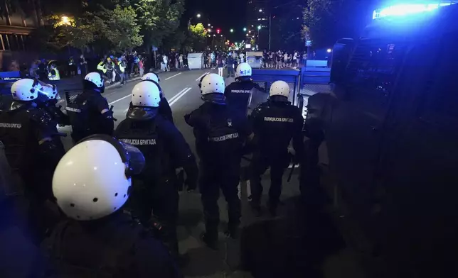 Serbian police officers guard a street during an anti-government protest near the Serbian Progressive Party office in Belgrade, Serbia, Friday, Aug. 15, 2025. (AP Photo/Darko Vojinovic)