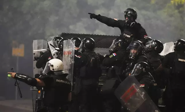 Serbian gendarmerie officers patrol in truck during an anti-government protest near Serbian Progressive Party office in Belgrade, Serbia, Friday, Aug. 15, 2025. (AP Photo/Darko Vojinovic)