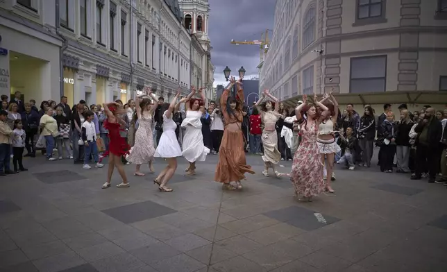 Young women meet to dance in a street near the Kremlin in Moscow, Russia, Monday, Aug. 18, 2025. (AP Photo/Alexander Zemlianichenko)