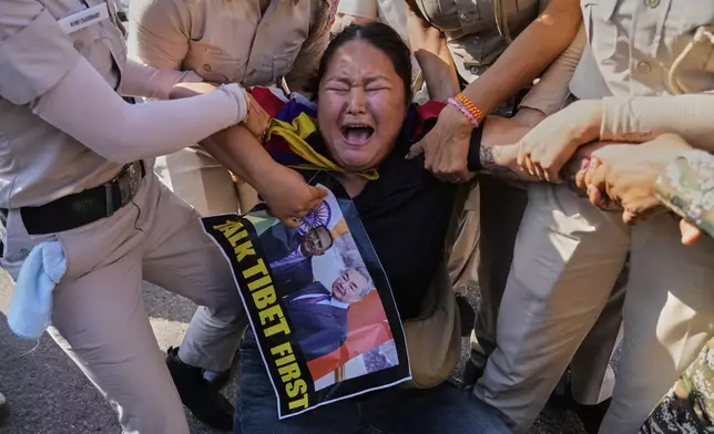 Policewomen detain an exiled Tibetan woman protesting against the visit of Chinese Foreign Minister Wang Yi to India, outside Chinese embassy in New Delhi, India, Monday, Aug. 18, 2025. (AP Photo/Manish Swarup)