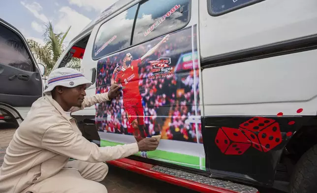 Brian Chitsike, a graphic designer installs an image of Liverpool Football Club winger Mohamed Salah on a minibus taxi, in Harare, Zimbabwe, Sunday, Aug. 10, 2025. (AP Photo/Aaron Ufumeli)