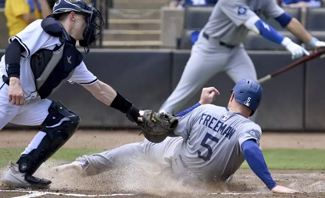 Los Angeles Dodgers' Freddie Freeman (5) celebrates after scoring on a single by Andy Pages during the sixth inning of a baseball game against the Tampa Bay Rays Sunday, Aug. 3, 2025, in Tampa, Fla. (AP Photo/Jason Behnken)