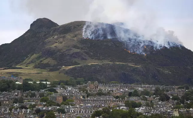View of flames and smoke from a fire on Arthur's Seat in Holyrood Park, Edinburgh, Scotland, Sunday Aug. 10, 2025. (Jane Barlow/PA via AP)