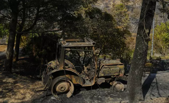 A burned agricultural machine is pictured after a fire during France's largest wildfire in decades in Albas, southern France, Thursday, Aug. 7, 2025. (AP Photo/Manu Fernandez)