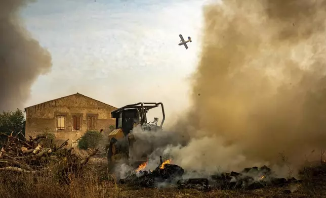 This photo, provided by the Securite Civile on Thursday Aug. 7, 2025, shows a plane flying over the wildfire near Saint-Laurent-de-la-Cabrerisse, southern France, Wednesday, Aug. 6, 2025. (Securite Civile via AP)