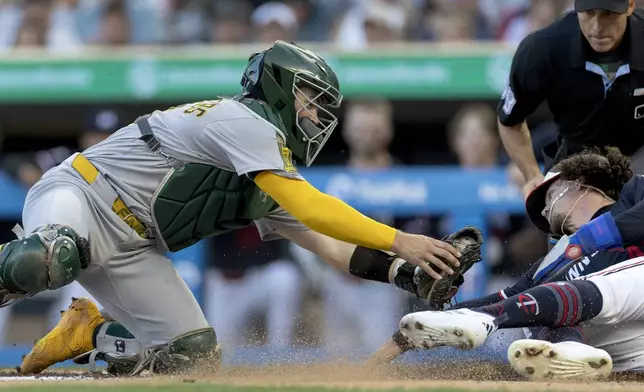 Athletics' catcher Shea Langeliers (23) tags out Minnesota Twins' James Outman (43) in the third inning of a baseball game at Target Field in Minneapolis, Wednesday, Aug. 20, 2025. (Carlos Gonzalez/Star Tribune via AP)