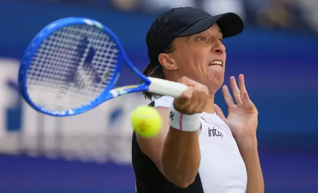 Iga Swiatek, of Poland, returns a shot to Emiliana Arango, of Colombia, during the first round of the US Open tennis championships, Tuesday, Aug. 26, 2025, in New York. (AP Photo/Yuki Iwamura)