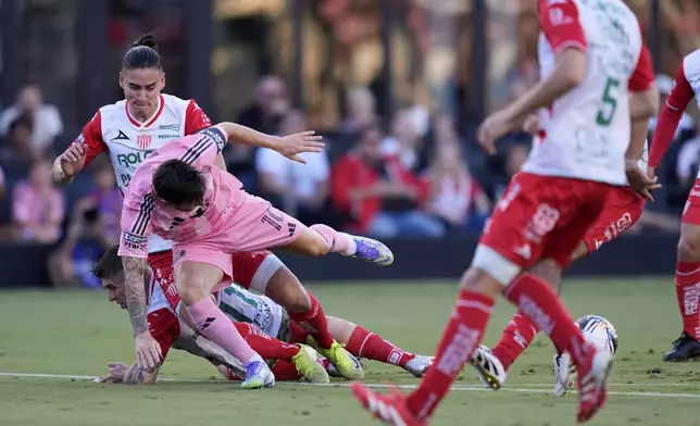 Inter Miami forward Lionel Messi (10) takes a tumble in a clash with Necaxa defenders Alexis Pena, top, and Cristian Calderon, bottom, during the first half of a Leagues Cup soccer match, Saturday, Aug. 2, 2025, in Fort Lauderdale, Fla. (AP Photo/Rebecca Blackwell)